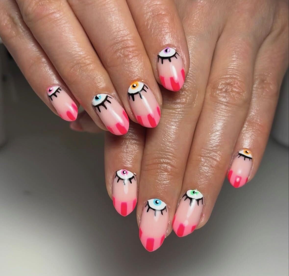 Hand-painted cartoon-eye nail set with hot-pink tips